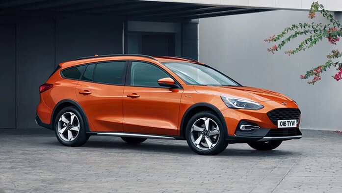 Orangener Ford Focus Active vor einem Haus